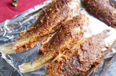 some fish are sitting on tin foil and ready to be grilled in the oven