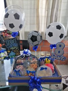 a table topped with balloons and soccer balls