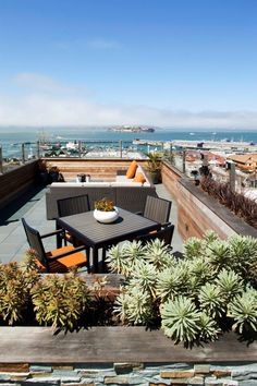 an outdoor table and chairs on top of a roof