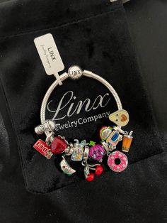 a charm bracelet with charms on it and the name luna jewelry company written in silver