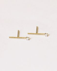 A 14k yellow gold stick earring with a small white diamond on the end. GJENMI is handmade in Los Angeles from conflict-free diamonds and ethically-sourced stones. –1.5mm white diamond Stick Earrings, Beauty Items, Conflict Free Diamonds, White Diamond, The End, Made In Usa, Hair Accessories, Diamonds, Angeles