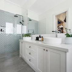 a large bathroom with two sinks and a shower stall in the corner, along with a walk - in shower