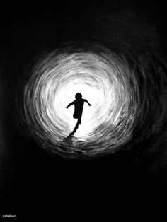 a person standing in the middle of a black and white tunnel with light coming from it