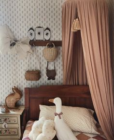 there is a stuffed swan sitting on the bed in this child's room,