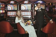 a bride and groom sitting in front of slot machines