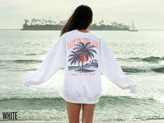 "Salt in the Air, Sand in My Hair" island sunset with palm trees crewneck sweatshirt.  This fabulous graphic will be printed on a Gildan 18000 Unisex Sweatshirt which runs true to size. If you are looking for an oversized fit, we recommend sizing up. Please refer to the size chart in the images. We use professional quality DGT printing on all our apparel. Direct-to-garment, or DTG, is a high quality printing method that sprays ink directly onto the garment so there is no peeling or cracking. Pro Beach Season Streetwear Sweatshirt Crew Neck, Summer Vacation Crew Neck Sweatshirt, Vacation Crew Neck Relaxed Fit Sweatshirt, Vacation Relaxed Fit Crew Neck Sweatshirt, Beach Crewneck, Summer Crewneck, Island Sunset, Beach Sweatshirt, Tropical Shirt