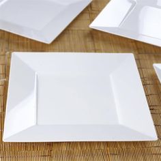 white square plates laid out on top of a bamboo tableclothed placemats