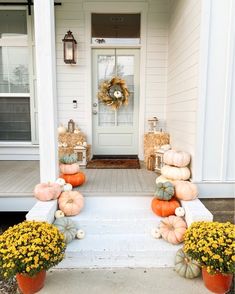 pumpkins and gourds sit on the front porch