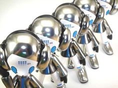 several shiny silver and black robot heads with earphones on their ears are lined up in a row