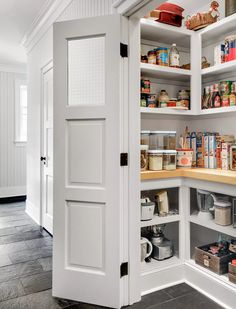 an open pantry door in a kitchen with lots of food on the shelves and other items