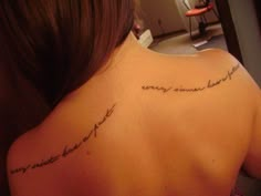 the back of a woman's shoulder with words written in cursive writing