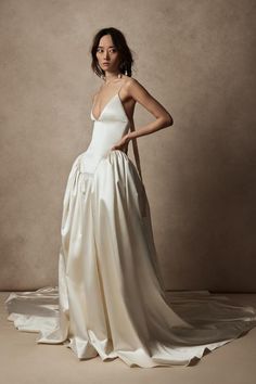 a woman in a white dress posing for the camera with her hands on her hips