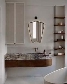 a bathroom with a sink, mirror and shelving unit in the wall next to it