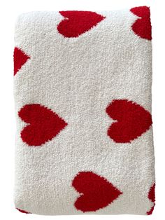 a red and white blanket with hearts on it's side, against a white background