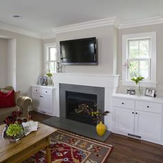 a living room filled with furniture and a flat screen tv mounted on the wall above a fire place