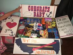 a box filled with candy sitting on top of a wooden floor next to a sign