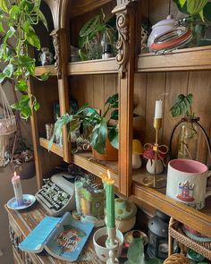 a wooden shelf filled with lots of potted plants and other things on top of it