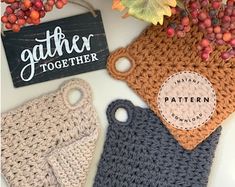 two crocheted bags are next to a sign that says gather together on it