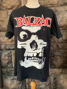 a black t - shirt with a skull on it and the word balzac written in red