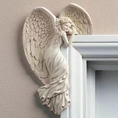 an angel figurine hanging on the side of a wall