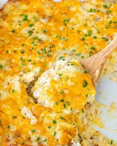 a casserole dish with chicken and cheese in it, on a wooden spoon