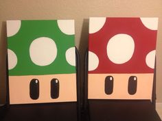 two pieces of paper with the faces of mario and luigi on them sitting on a table