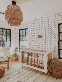 a baby's room with a crib in the middle and lots of windows