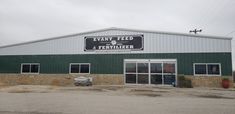 the front of a building that is green and has a sign on it saying, swamp feed & fertiizer