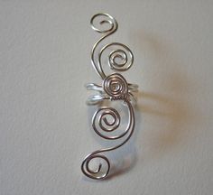 This listing is for a pair (2) of ear cuffs with double swirls in both directions. Graceful swirls made of 20g wire wind up and down from the central ear cuff adorned with a fifth swirl. Very popular design has been requested in pairs, so here it is, and at a savings too! This ear cuff is also available as a single cuff. Available in gold tone, silver plated, Silver Filled, .925 Sterling Silver, and NEW 14K Gold Filled Wire! Metal Options: .925 Sterling, this is solid 925 sterling silver. The .9 Silver Spiral Adjustable Ear Cuff, Wrap Earrings, Gold Bond, Ear Cuffs, Wire Wrapped Jewelry, Pure Silver, Jewelry Ideas, Solid 925 Sterling Silver, Ear Piercings