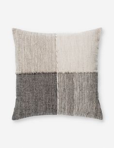 a gray and white pillow with two different colors on the front, one black and one beige