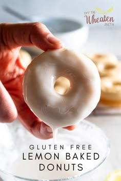 a person holding a glazed donut in front of some doughnuts on a plate