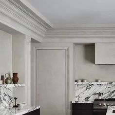 a kitchen with marble counter tops and black cabinets