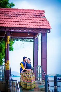 a man and woman standing in front of a gazebo on the steps next to each other