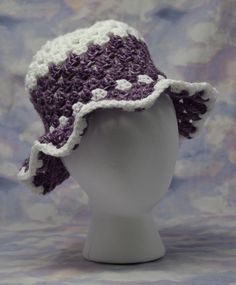 a white mannequin head wearing a purple and white crochet sun hat