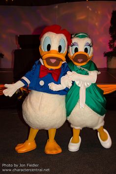 two donald and daisy characters standing next to each other