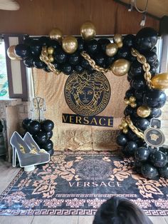 a black and gold balloon arch for a versa party with high heels on the floor