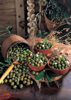 there are some green peas in small bowls on the table next to other plants and vegetables