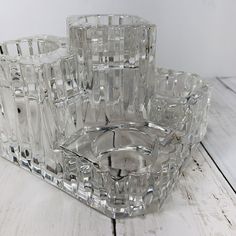 four clear glass dishes sitting on top of a white wooden table next to each other