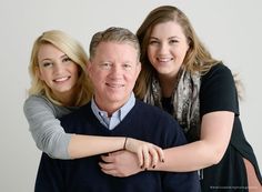 an older man and two younger women hugging each other