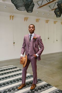 a man in a suit and hat standing on a rug