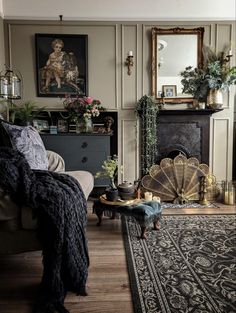 a living room filled with furniture and a fire place next to a rug on top of a hard wood floor