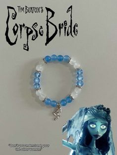 an image of a bracelet with blue beads and a fairy tale character charm on it