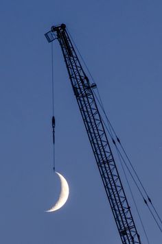 a crane is lifting a half moon in the sky with it's back end