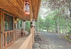 the front porch of a log cabin with wood siding and stone steps leading up to it