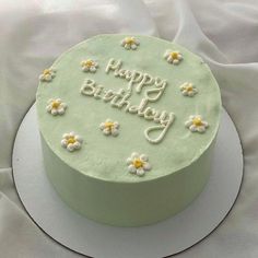 a birthday cake decorated with daisies and the words happy birthday written on frosting