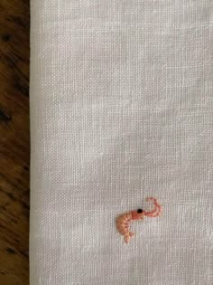 an embroidered piece of cloth on top of a wooden table