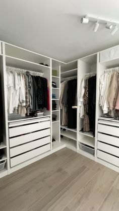 a white closet filled with lots of clothes