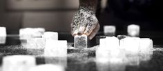 a person reaching for ice cubes on a table