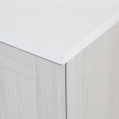 a close up view of the top of a white cabinet with wood grained doors