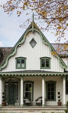 a white house with green trim and windows